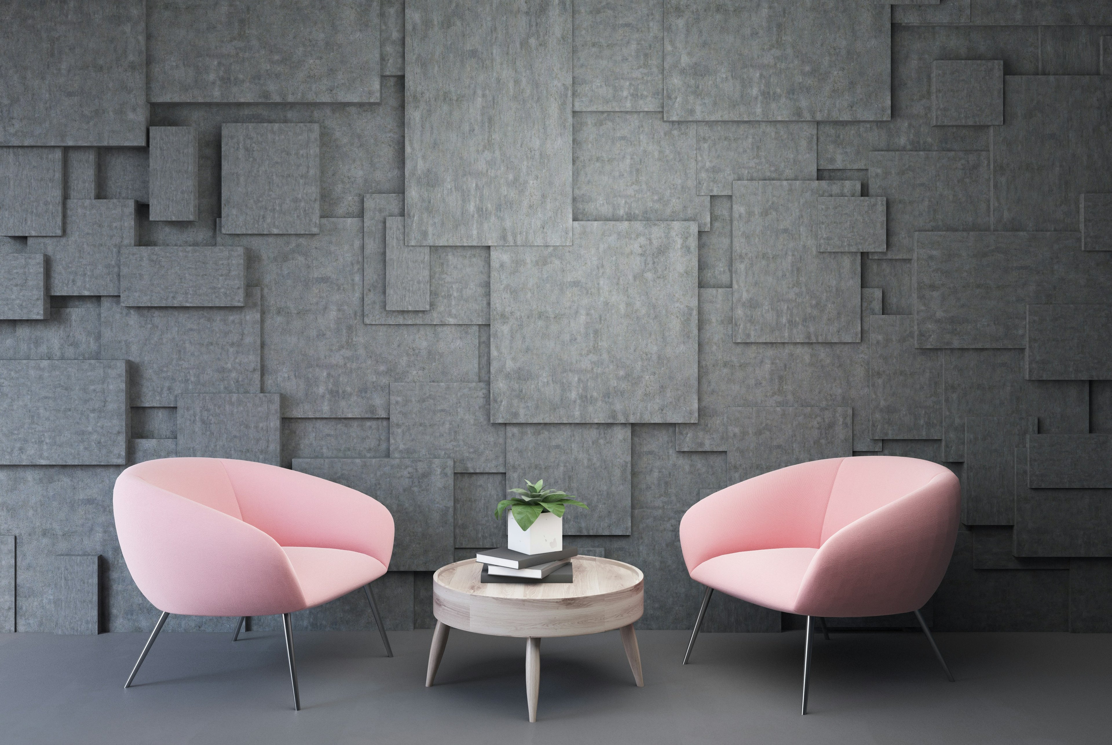 Two pink chairs and a small round table against a textured gray wall.